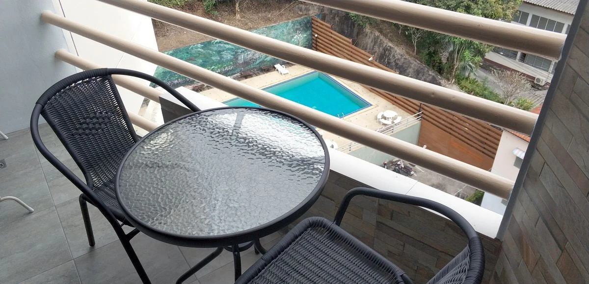Balkon der Eigentumswohnung in Chiang Rai mit Panoramablick auf Berge und Pool